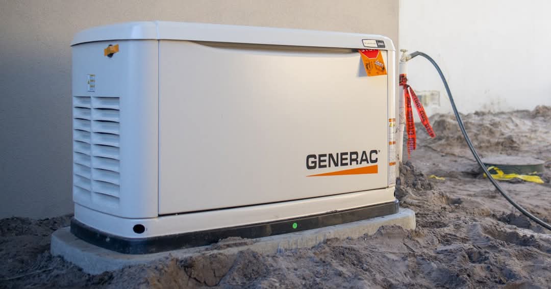 Generac home standby generator installed on a concrete pad beside a house